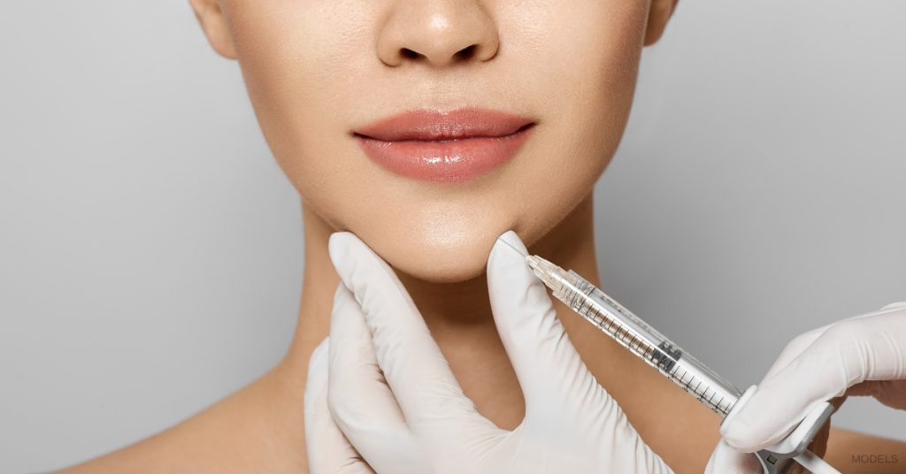 Beautiful woman getting skin injectable treatment on her chin (MODELS)